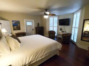 um quarto com uma cama branca e uma televisão de ecrã plano em Villa Mulvey #1 em Saint Augustine