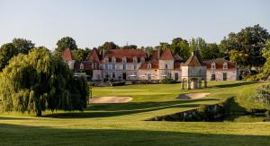 an old mansion on a golf course with a pond at Château des Vigiers in Monestier