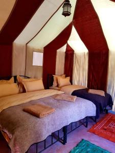 メルズーガにあるSahara Nomad Campのテントの中にベッドが2つある寝室 +30枚の写真