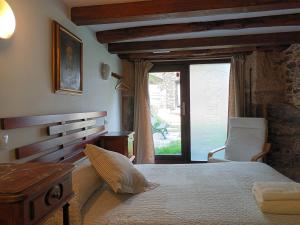 a bedroom with a bed and a chair and a window at Mercadoiro in Laje
