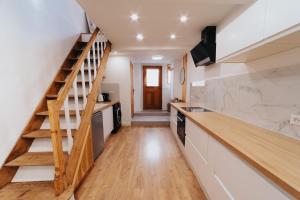 a kitchen with a wooden staircase and white counters at Perfect family-oriented and renovated townhouse in the old Antibes in Antibes