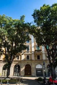 budynek z drzewami przed nim w obiekcie Madeleine apartments - Arco della Pace w Mediolanie