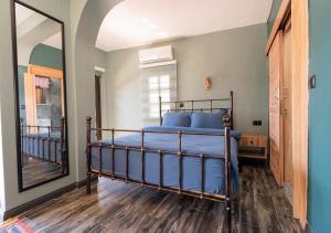Schlafzimmer mit einem Bett mit blauer Bettwäsche und einem Spiegel in der Unterkunft Liman Deluxe Hotel in Marmaris