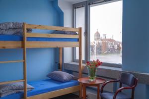 a bunk bed in a room with a window at Hostel Gdańsk Szafarnia 10 Old Town in Gdańsk