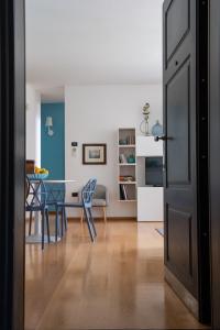 Madeleine apartments - Appartamento di charme في ميلانو: مطبخ وغرفة طعام مع طاولة وكراسي