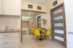 Una cocina y un comedor con una mesa y sillas amarillas. en Noclegi na Ogrodowej, en Sandomierz 10 fotos más