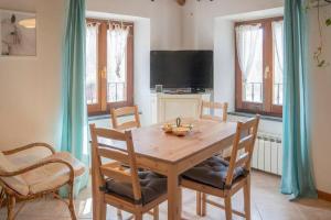 - une salle à manger avec une table et des chaises en bois dans l'établissement 036 - La Casa di PIETRA Maissana Relax e Natura, à Chiama