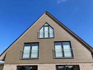 una casa con ventanas en un cielo azul en Lagertha - Maisonette, en Büsum