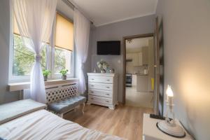 ein Schlafzimmer mit einem Bett, einer Kommode und einem Fenster in der Unterkunft Noclegi na Ogrodowej in Sandomierz