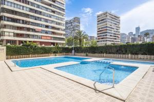 a swimming pool in a building with tall buildings at Veracruz 20-E in Benidorm