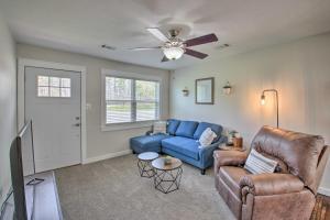 a living room with a blue couch and a ceiling fan at Cozy Hideaway By Lake Ouachita and Hot Springs! in Hot Springs Village