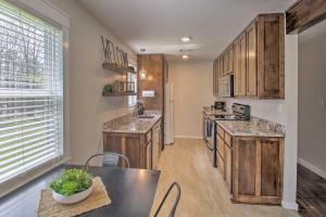 a kitchen with wooden cabinets and a table and chairs at Cozy Hideaway By Lake Ouachita and Hot Springs! in Hot Springs Village