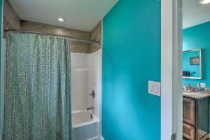 a bathroom with a shower with a blue wall at Cozy Hideaway Near Lake Ouachita and Hot Springs! in Hot Springs Village +17 photos