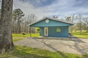 a blue tiny house in a park with a tree at Cozy Hideaway Near Lake Ouachita and Hot Springs! in Hot Springs Village