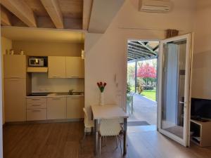 kuchnia i jadalnia ze stołem i telewizorem w obiekcie Agriturismo Dell'Orto Apartments w Weronie