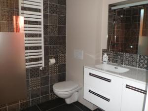 a bathroom with a toilet and a sink and a mirror at HEUREUX HASARD in Clisson