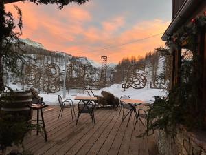 a patio with tables and chairs in the snow at La Luge in Valtournenche
