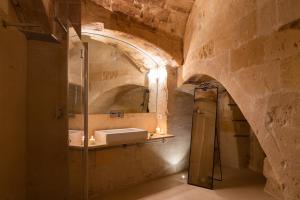 a bathroom with a sink and a mirror at Suite Santa Maria - L'Opera Dell'Architetto in Matera