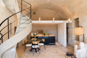 a room with a table and chairs and a staircase at Suite Santa Maria - L'Opera Dell'Architetto in Matera