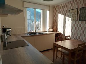 a kitchen with a sink and a table and a window at La Porte Rose in Rochesson