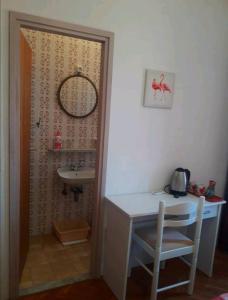 a bathroom with a sink and a table and a chair at Rooms Ankica in Primošten