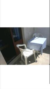 two white chairs and a table and a table and chairs at Rooms Ankica in Primošten