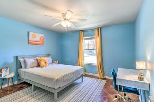 a bedroom with blue walls and a bed with a ceiling fan at Charming Burnet Cottage with Lake View and Porch! in Burnet