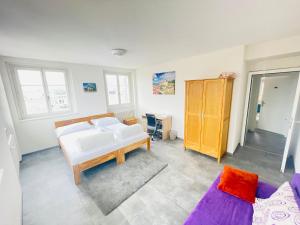 een woonkamer met een bed en een bank bij The 5 continents III - Premium appartment by Stay Swiss in Porrentruy