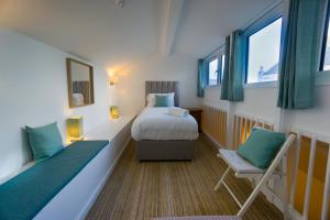 een kleine kamer met een bed en een stoel bij Largigi, Free Parking, Close to the Beach and Town Centre Rooms in Lyme Regis
