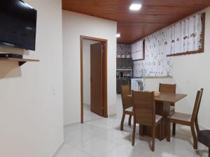 a kitchen and dining room with a table and chairs at Casa Aconchego visconde de Mauá in Itatiaia