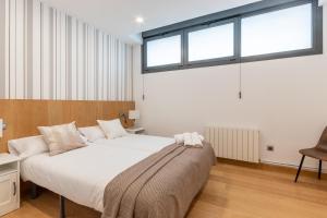 Łóżko lub łóżka w pokoju w obiekcie NEW! Lovely 3-Bedroom Loft in Bilbao