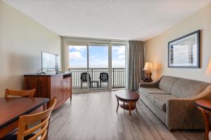 a living room with a couch and a table at Sandy Beach Resort in Myrtle Beach +37 photos