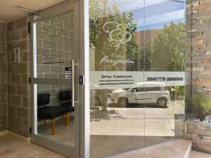 una puerta a un concesionario de coches con un coche en la ventana en Apartamentos Boulevard II en San Rafael