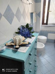 Un baño con un mostrador azul con flores. en Alcivico26 en Alghero