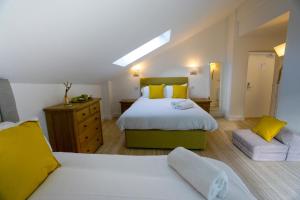 a bedroom with a large bed and yellow pillows at Largigi, Free Parking, Close to the Beach and Town Centre Rooms in Lyme Regis