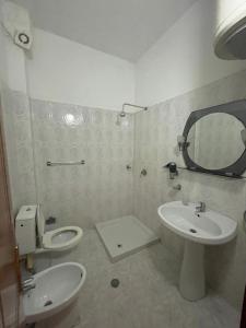 a bathroom with a sink and a toilet and a mirror at Seashell Beach Rooms in Durrës +73 photos