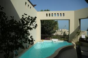 uma piscina no meio de uma casa em Private guest house in five stars resort em Ras al-Khaimah