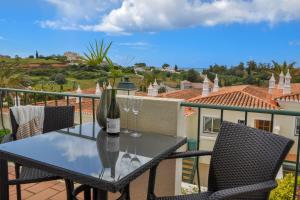 - une table avec une bouteille de vin sur le balcon dans l'établissement 2BR Townhouse w/Pool - Amazing Views, 5mn to Beach by LovelyStay, à Ferragudo