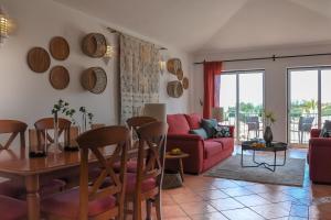 a living room with a table and a red couch at 2BR Duplex Townhouse with access to Pool - 5mn to Beach by LovelyStay in Ferragudo