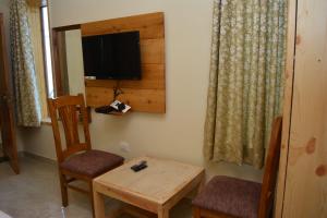 Habitación con mesa, silla y TV. en Memento Vivere, en Kanatal