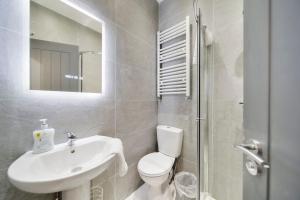 a bathroom with a toilet and a sink and a mirror at Magee Town House 'Sleeping 8 guests' in Londonderry County Borough