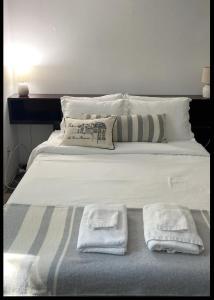 - un grand lit blanc avec 2 serviettes dans l'établissement St.James st Teahouse, à Kingston