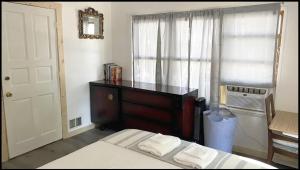 - une chambre avec un lit, une commode et une fenêtre dans l'établissement St.James st Teahouse, à Kingston
