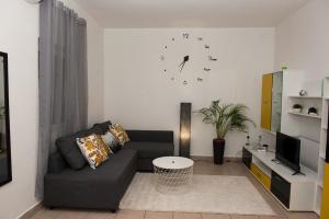 ein Wohnzimmer mit einem Sofa und einer Uhr an der Wand in der Unterkunft Vera in Zadar