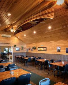 jadalnia z drewnianymi sufitami, stołami i krzesłami w obiekcie Big Horn Valley Ranch w mieście Fort Smith