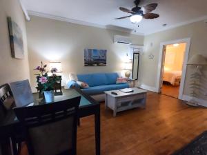 ein Wohnzimmer mit einem blauen Sofa und einem Tisch in der Unterkunft Villa Mulvey #2 in St. Augustine