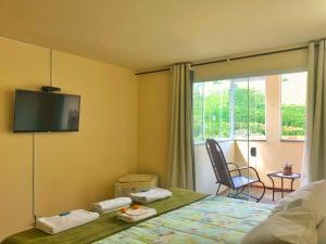 a bedroom with a bed with a television on the wall at Estalagem e Restaurante Cantinho Bistrô in Caparaó Velho