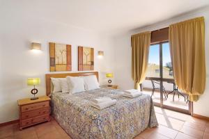 een slaapkamer met een bed en een balkon bij Villa Fernando in Quarteira