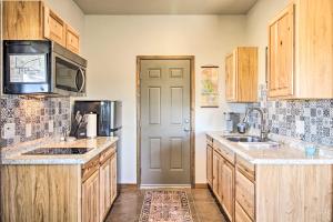 a kitchen with wooden cabinets and a sink and a microwave at Cozy Elgin Casita with Gas Grill Pets Welcome! in Elgin