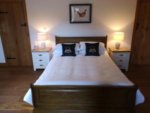 een slaapkamer met een groot bed met 2 nachtkastjes bij The Old Smithy Bed & Breakfast in Craven Arms